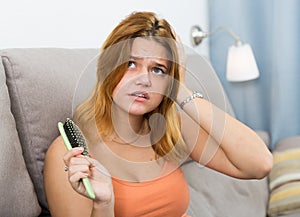 Young woman is nervous because her hair suffers from avitaminosis