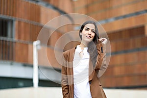 Young woman with nice hair standing outside of office building.