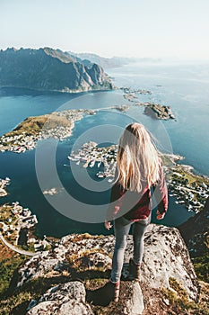 Young woman in Norway standing alone on cliff mountain