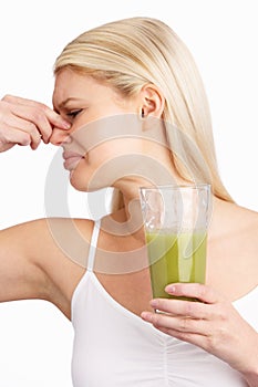 Young Woman Not Enjoying Healthy Drink In Studio