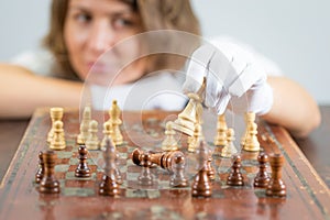 Young woman nurse doctor playing chess checkmate thinking game pieces.