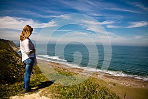 Young woman observing picturesque atlantic coast in springtime