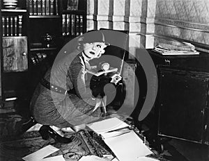 Young woman in an office next to a safe, looking over her shoulder