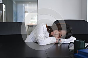 Young woman office worker tired from working and take a nap from depressed work.