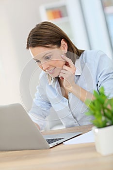 Young woman in the office working on a laptop photo