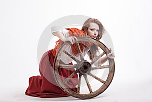 Young woman with an old wagon wheel