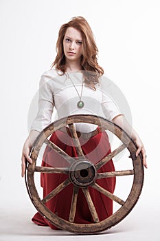 Young woman with an old wagon wheel