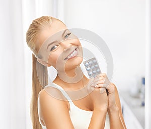 Young woman with one pack of pills