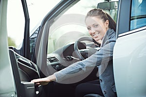 Young woman opening car door