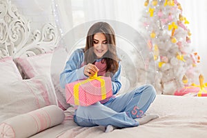 Young woman opening christmas present