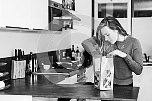 Young woman opens a package of fresh ingredients