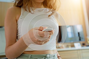 Young woman operates wireless security system in a modern apartment.