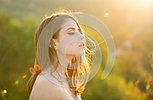 Young woman outdoor enjoying the sunlight. Spring romantic casual woman portrait. Beautiful girl looking eways in summer photo