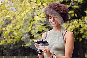 Young Woman Outdoors With DSLR Camera Taking Photos In City Park