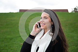 Young woman outdoors talking on cellphone