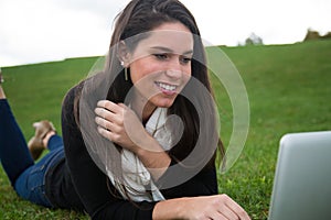 Young woman outdoors talking on computer