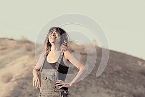 Young woman in overalls laughing