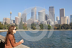 Young woman overlooks the bay and skyline of Sydney