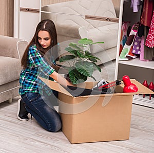 Young woman packing personal belongings