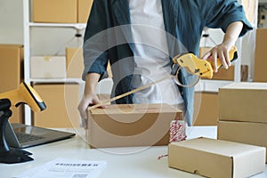 Young woman packing product in box for online order.