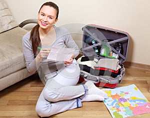 Young woman packing suitcase