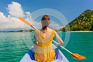 Young woman paddling a canoe during vacation in Flores Island