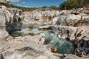 Young woman is paddling in the river Ceze at Cascades Du Sautadet.