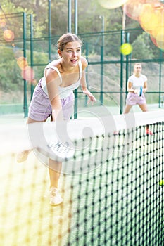 Young woman padel tennis player trains on the outdoor court