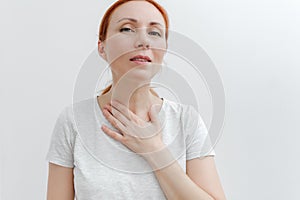Young woman with pain in throat,toothache. Women touches the throat. White background. Close-up view