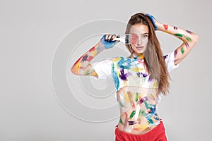 Young woman smeared in multicolored paint.