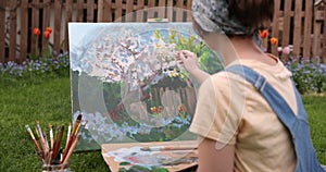 Young woman painting flowers in the garden