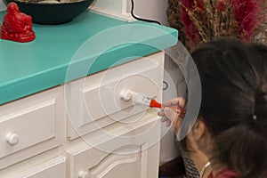 Young woman painting furniture at home