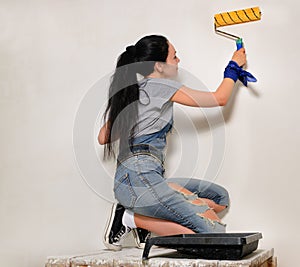 Young woman painting with a roller