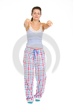 Young woman in pajamas sleep walking