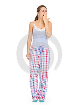 Young woman in pajamas yawing