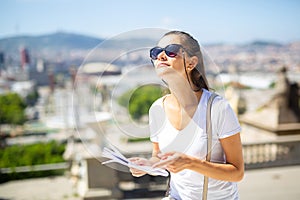 Young woman with paper guide observing sightseeings