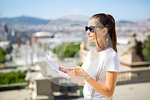 Young woman with paper guide observing sightseeings