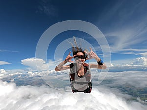 Young woman parachutist smiling in free fall.