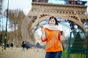 Young woman in Paris with coffee and croissant