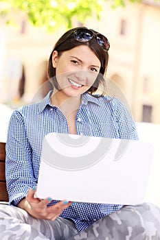 Young woman in the park with laptop