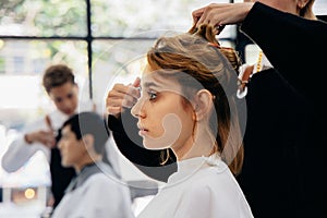 Young woman in parlour getting hairstyling