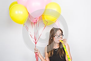 Young woman with party hat with noisemaker on a white background