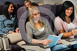 Young woman passenger read book airplane flight