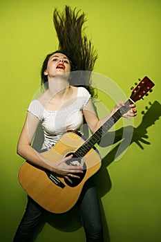 Young woman passionately playing guitar