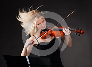 Young woman passionately playing violin