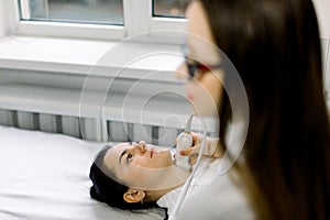 Young woman patient having thyroid ultrasound checkup in the clinic