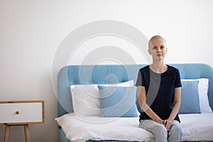 Young woman patient sitting at modern ward at oncology center