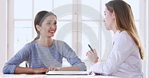 Young woman patient talking to female doctor at medical checkup