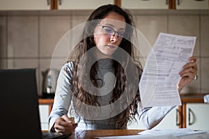 Young woman paying the bill online on her computer with credit card