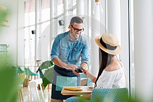 Young woman paying for cafe by credit card reader. - Image